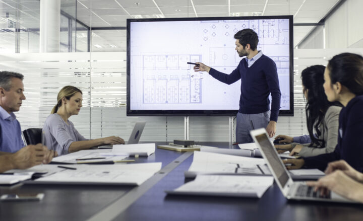 Business Meeting With Presentation And Laptops.