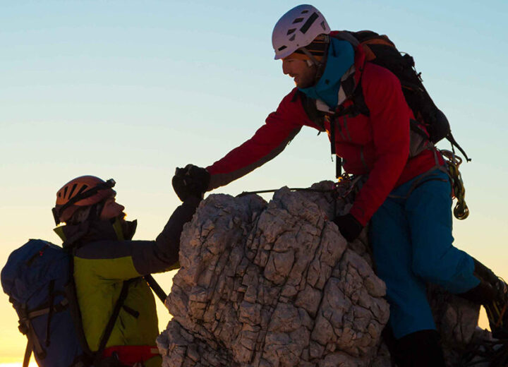 Climbers Reaching The Summit Together.