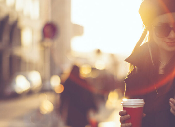 Woman Holding Coffee And Smartphone Outdoors.