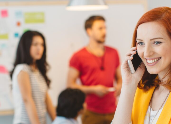 Woman Talking On Phone In Meeting.