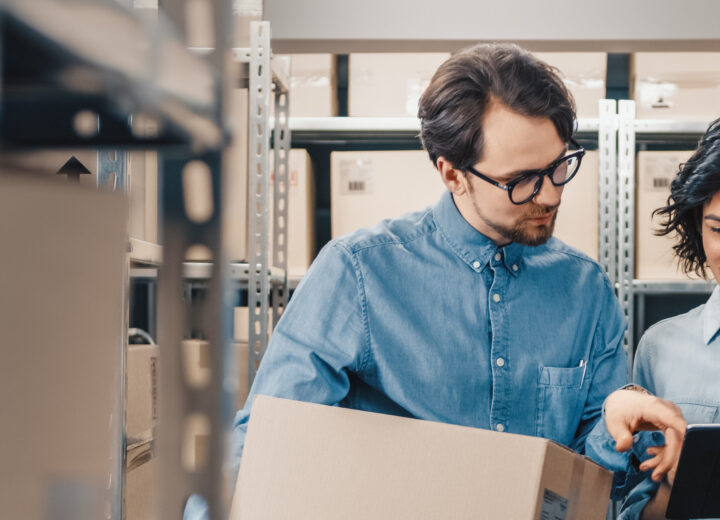 Two People Discussing Inventory In Storage.
