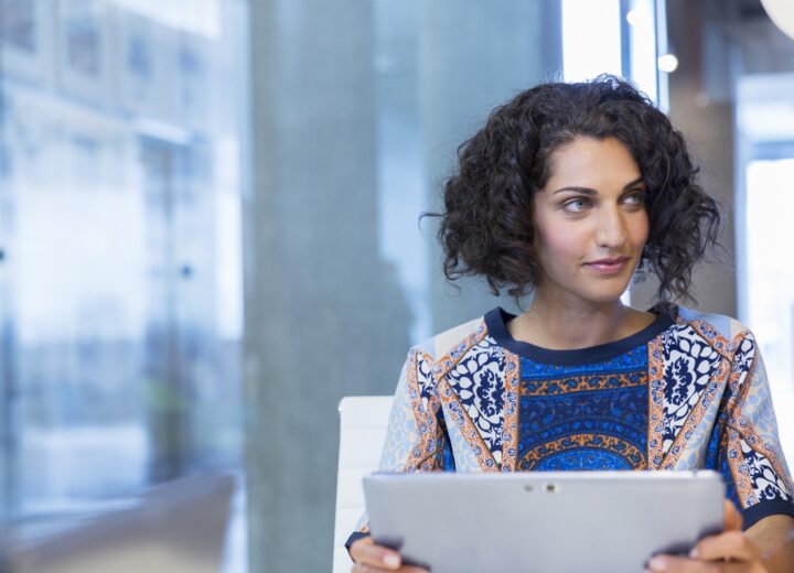Person Using Tablet In Modern Office.