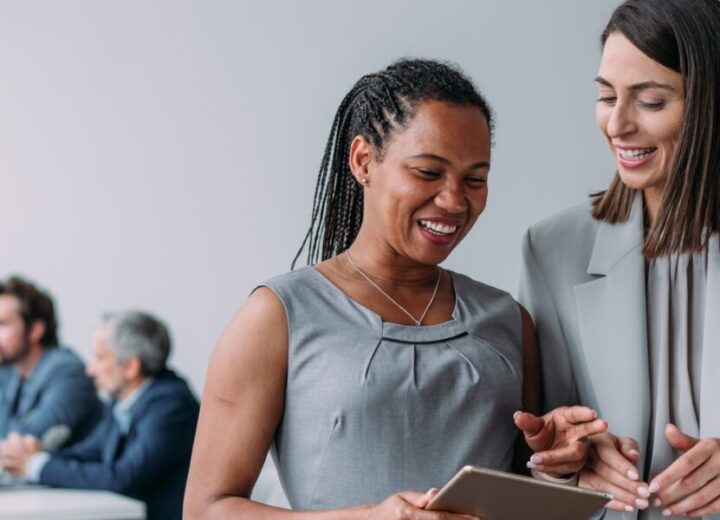 Two Women Discussing In Modern Office.