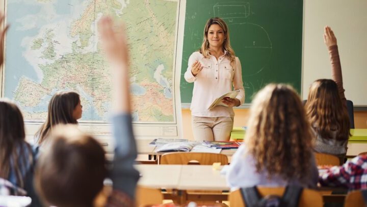 Students Raising Hands In Classroom