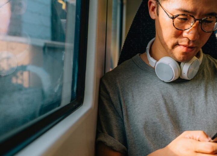 Person Using Phone On Public Transport.